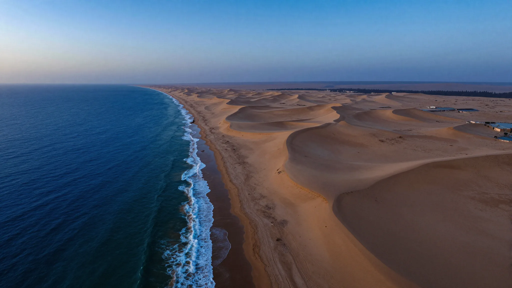 Vue aérienne de Dakhla à l'aube, là où les dunes du Sahara rencontrent l'océan Atlantique.